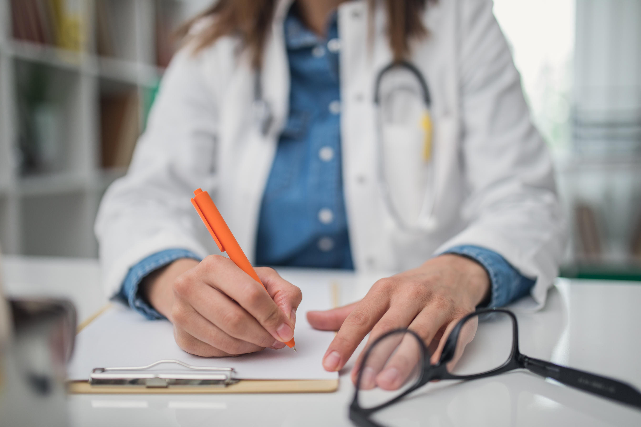 Woman doctor writing prescription